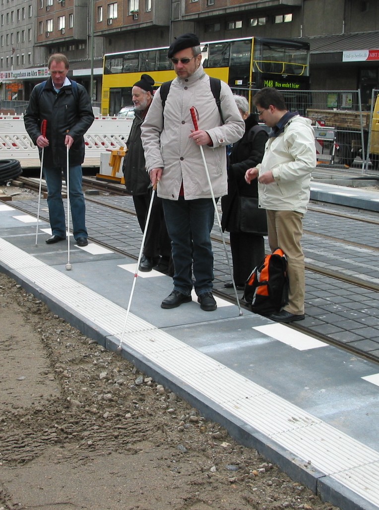 Mitglieder des GFUV testen auf einer Baustelle f&uuml;r eine Stra&szlig;enbahnhaltestelle einen neuen Leitstreifen